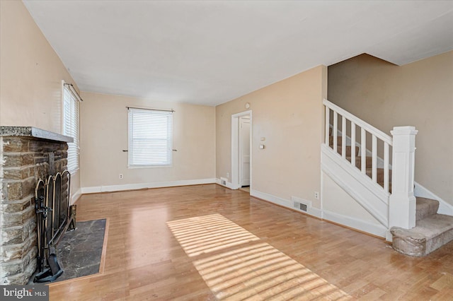 unfurnished living room with wood-type flooring and a fireplace