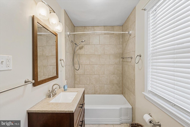 bathroom featuring tiled shower / bath combo and vanity