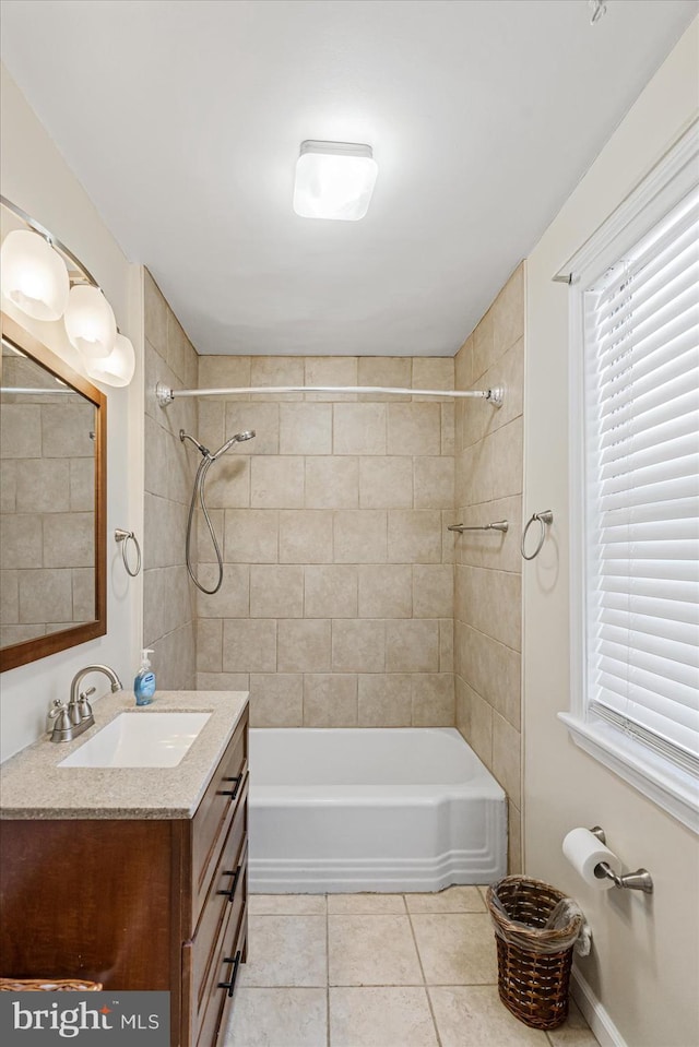 bathroom featuring tiled shower / bath, tile patterned floors, and vanity