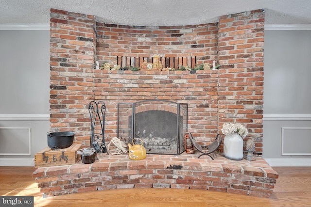 details featuring crown molding, hardwood / wood-style floors, and a textured ceiling