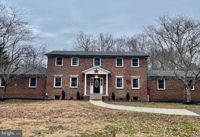 colonial inspired home featuring cooling unit and a front yard