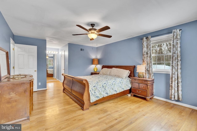 bedroom with ceiling fan, connected bathroom, and light hardwood / wood-style floors