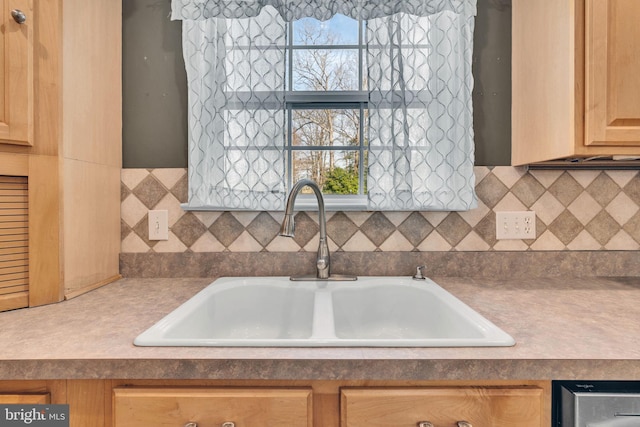 kitchen with a healthy amount of sunlight, sink, backsplash, and light brown cabinetry