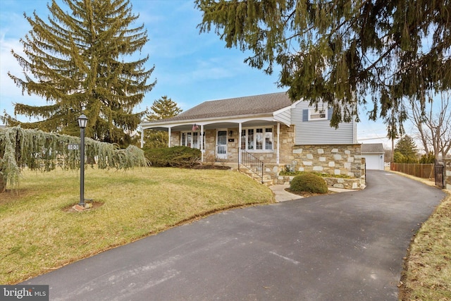 view of front of property with an outbuilding, a garage, a front lawn, and a porch