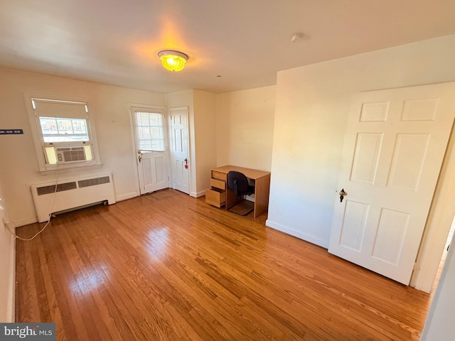 foyer featuring light hardwood / wood-style floors, radiator, and cooling unit