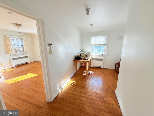 hallway featuring radiator, light hardwood / wood-style flooring, and plenty of natural light