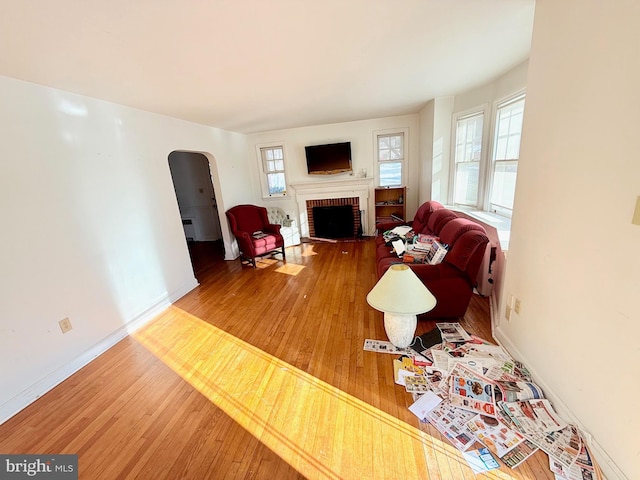 living room with hardwood / wood-style flooring and a brick fireplace