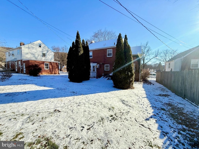 view of snow covered back of property