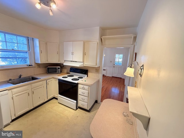 kitchen featuring sink, radiator heating unit, light hardwood / wood-style flooring, white appliances, and white cabinets