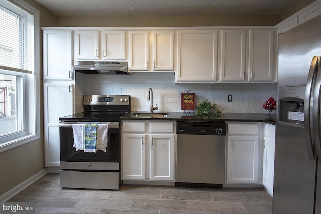 kitchen featuring decorative backsplash, sink, white cabinets, and stainless steel appliances