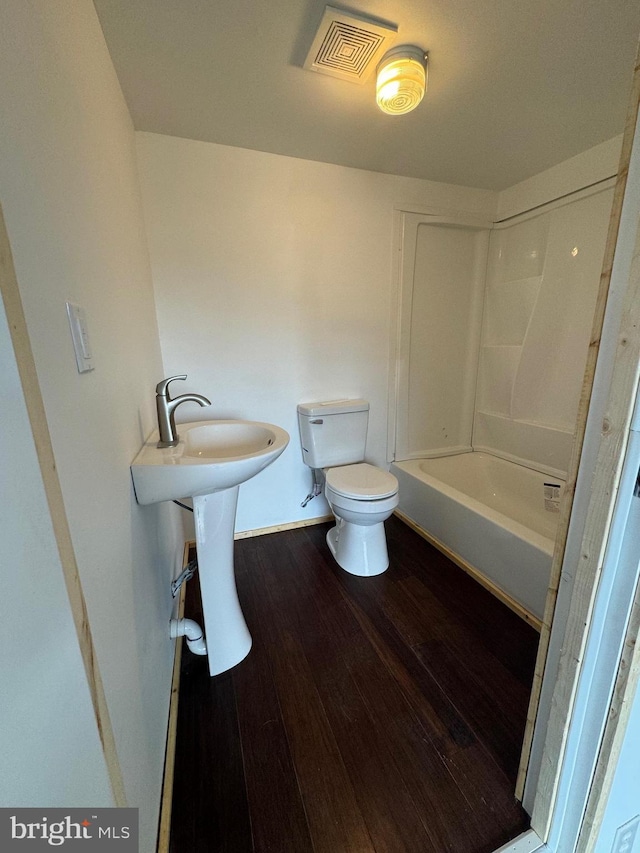 full bathroom featuring toilet, hardwood / wood-style flooring, shower / bathtub combination, and sink