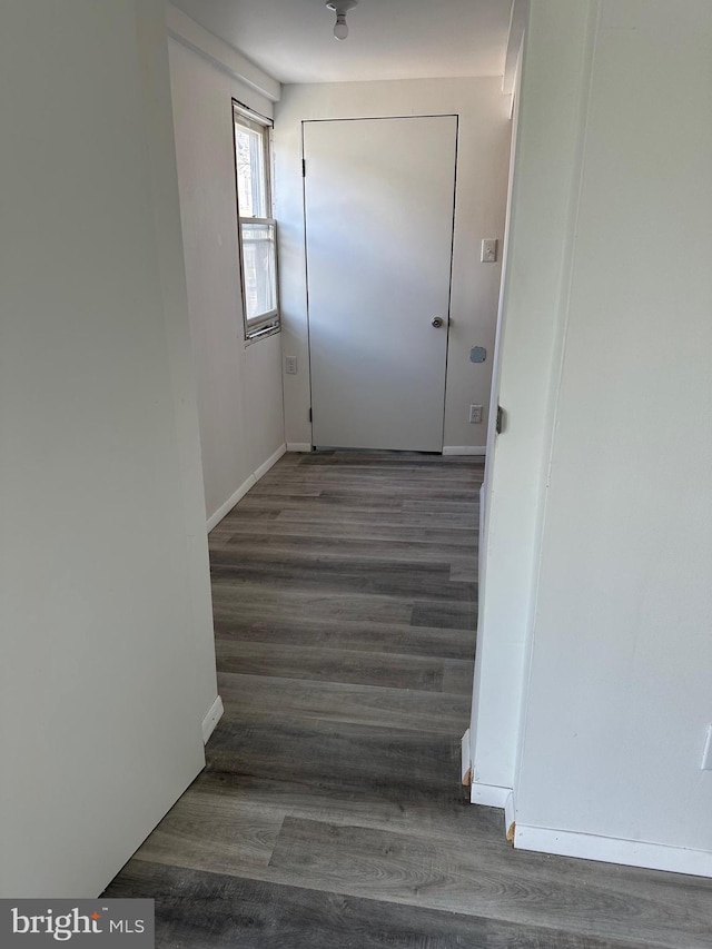 hallway with dark hardwood / wood-style flooring