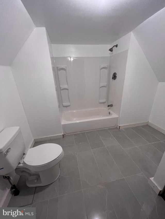 bathroom featuring toilet, shower / washtub combination, and tile patterned floors