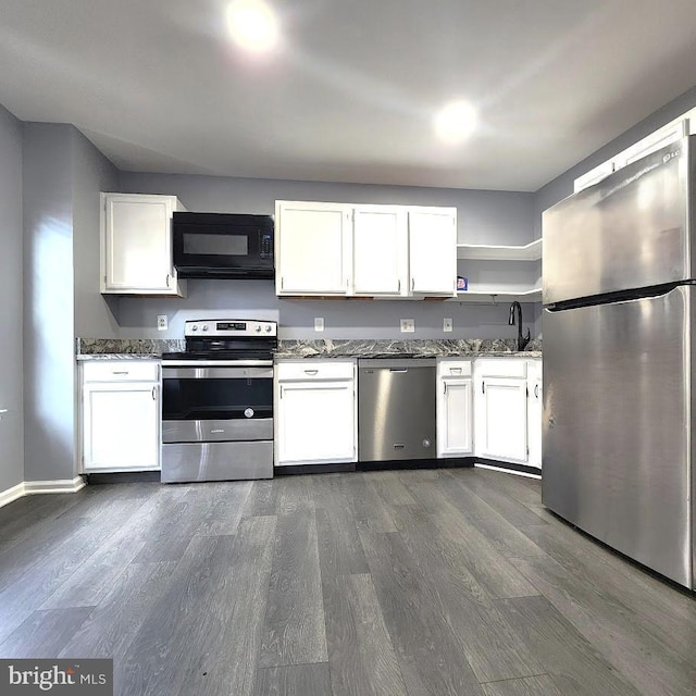 kitchen featuring white cabinets, dark stone counters, and appliances with stainless steel finishes