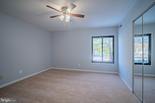 spare room with ceiling fan and light carpet