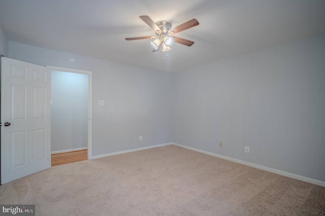 carpeted spare room featuring ceiling fan