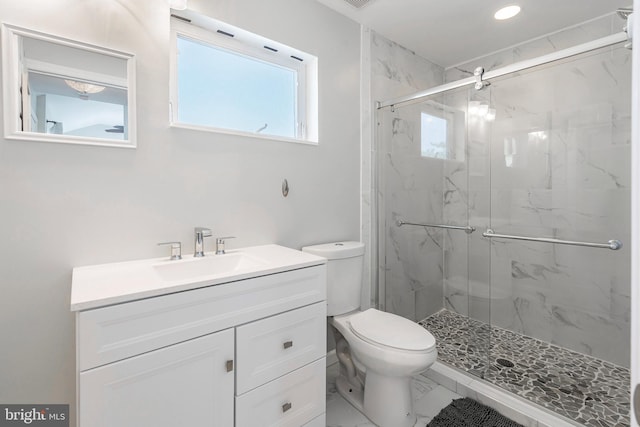 bathroom with vanity, toilet, and a shower with shower door