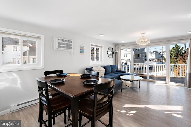 dining space featuring a baseboard radiator, a wall unit AC, and hardwood / wood-style flooring