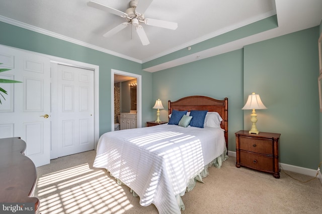 carpeted bedroom with ceiling fan, ensuite bath, ornamental molding, and a closet