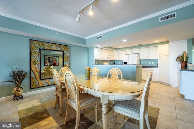 dining area featuring light tile patterned floors, a textured ceiling, and ornamental molding