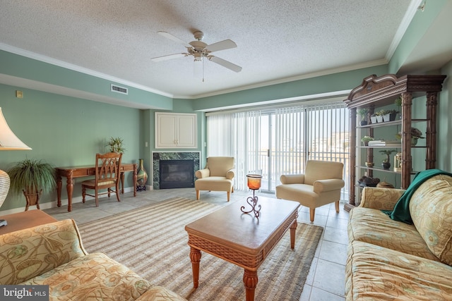 living room with a fireplace, light tile patterned floors, a textured ceiling, and ornamental molding