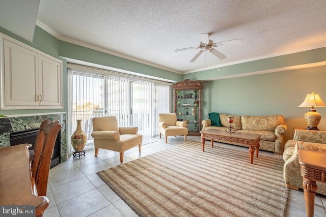 tiled living room featuring ceiling fan, crown molding, and a textured ceiling