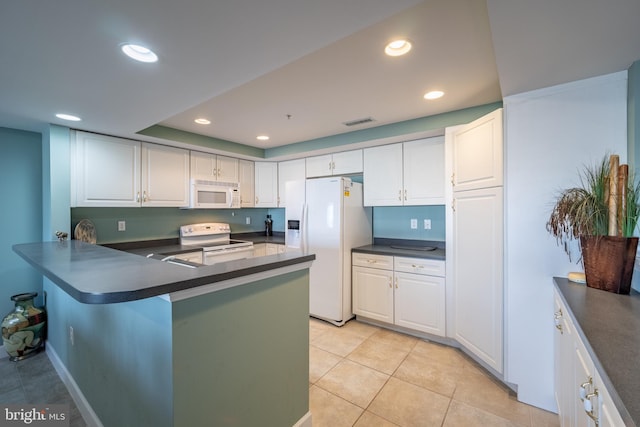 kitchen with kitchen peninsula, white appliances, and white cabinetry