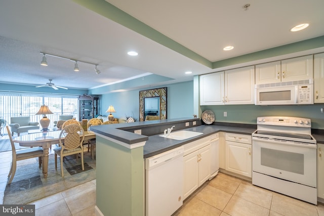 kitchen with white appliances, sink, a tray ceiling, white cabinetry, and kitchen peninsula