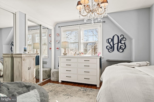 bedroom with dark hardwood / wood-style flooring and a chandelier