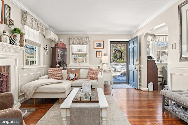 living room with ornamental molding, dark hardwood / wood-style floors, and a wall mounted AC