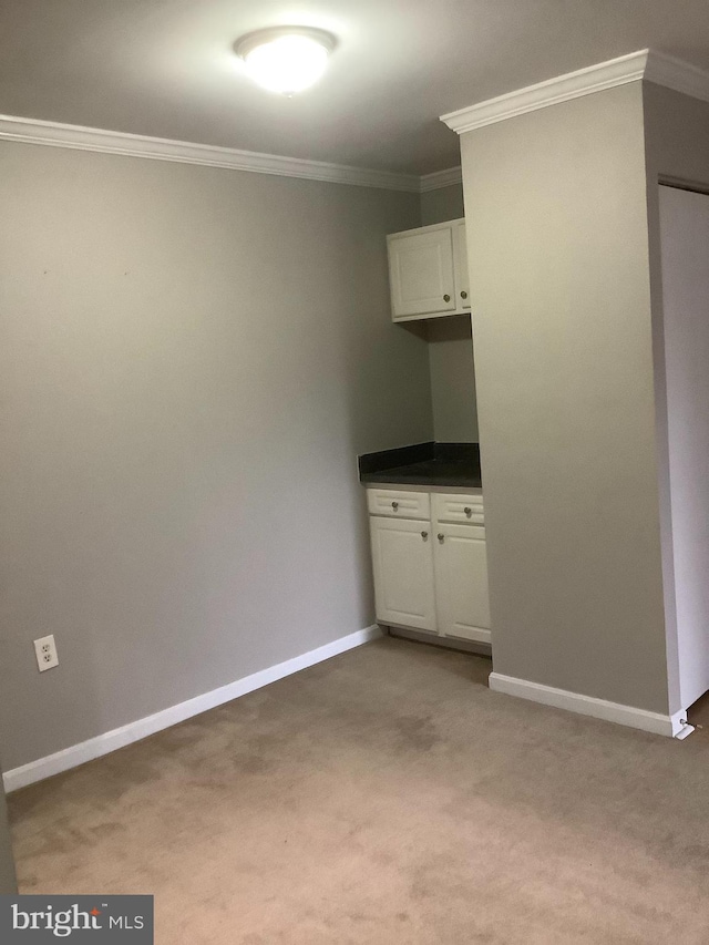 unfurnished bedroom with light carpet and crown molding