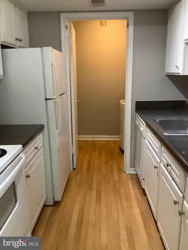 kitchen featuring white cabinets, light wood-type flooring, and white appliances