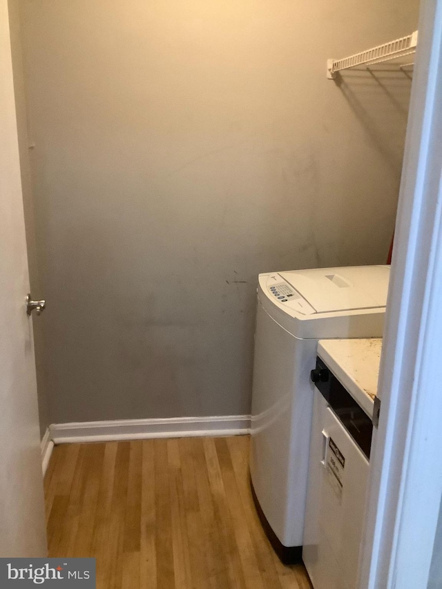 laundry room with washer and dryer and light wood-type flooring