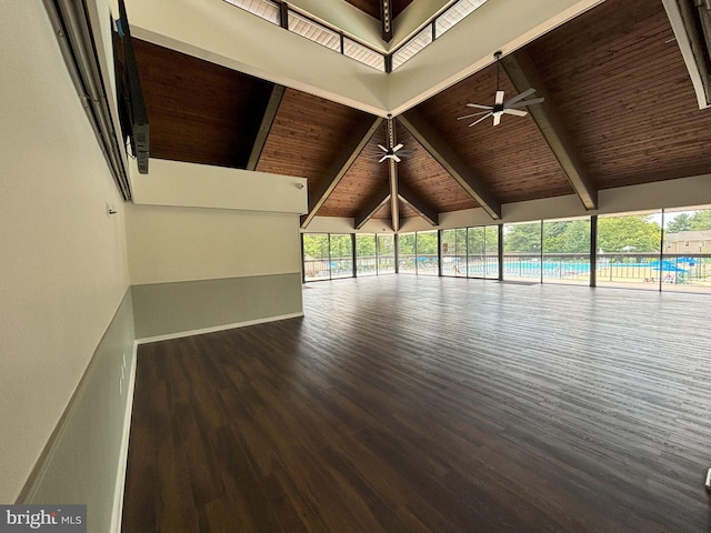 empty room with wooden ceiling, high vaulted ceiling, beam ceiling, dark wood-type flooring, and ceiling fan