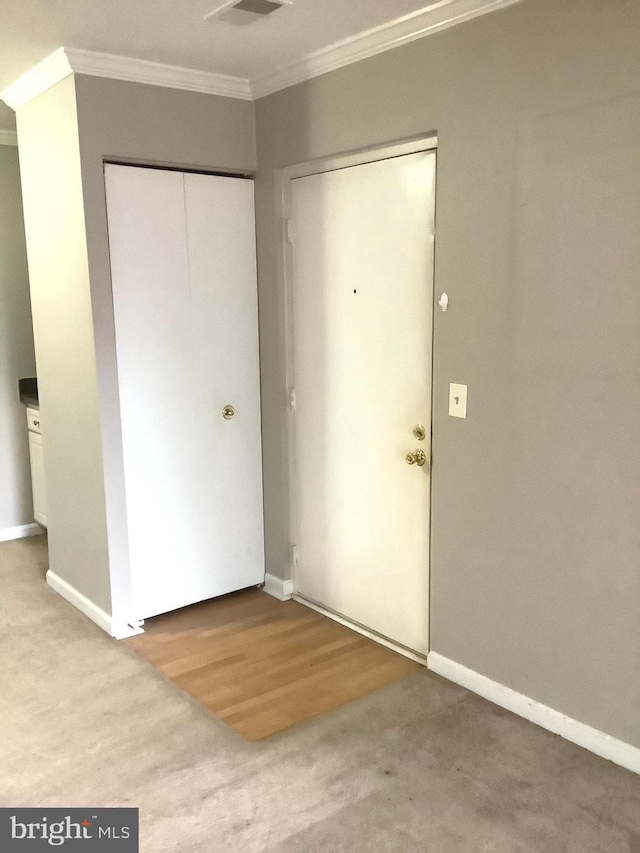 foyer entrance featuring hardwood / wood-style floors and crown molding