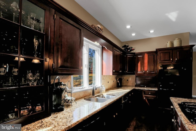 kitchen with tasteful backsplash, sink, dark brown cabinetry, light stone counters, and black gas stovetop