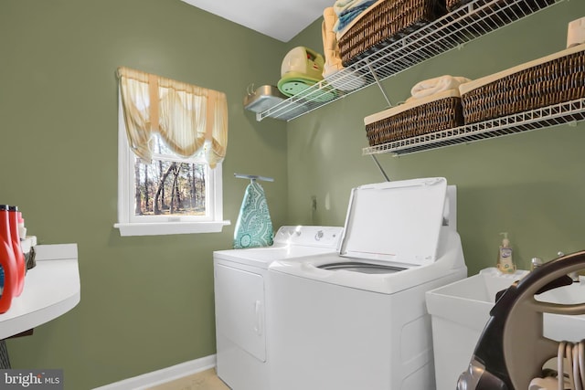 clothes washing area featuring separate washer and dryer and sink