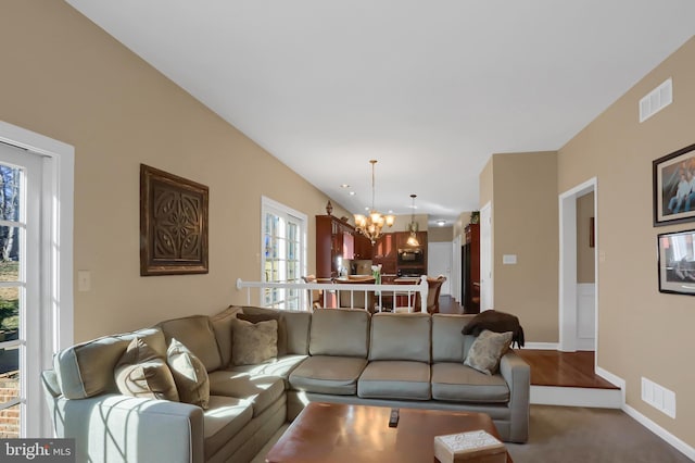 living room with carpet flooring and a notable chandelier