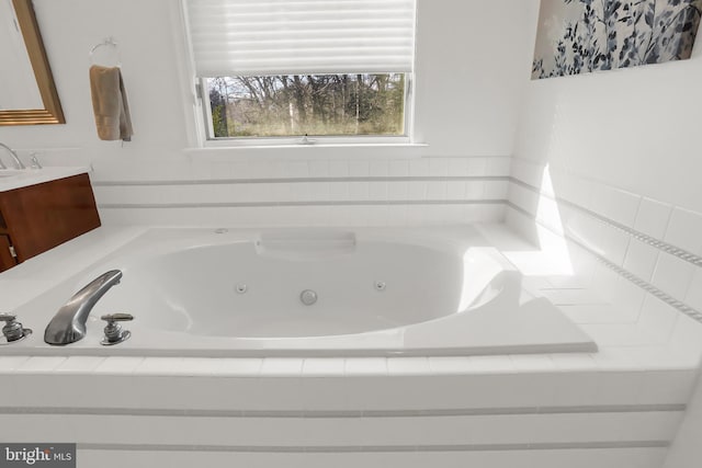 bathroom with vanity and tiled bath