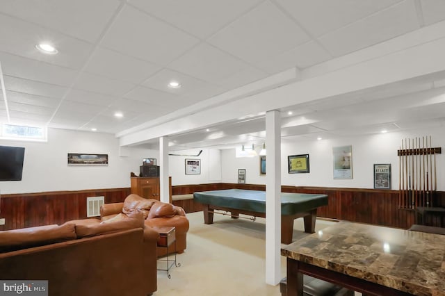 playroom featuring a paneled ceiling, carpet, and wood walls