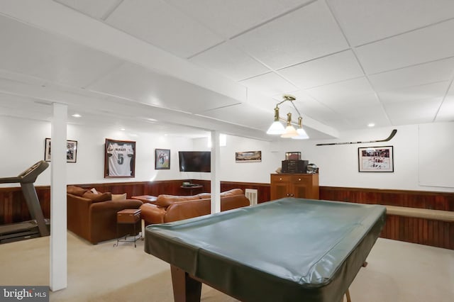 recreation room featuring light carpet, a drop ceiling, pool table, and wood walls