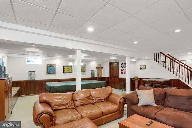 living room with billiards, wooden walls, and a drop ceiling