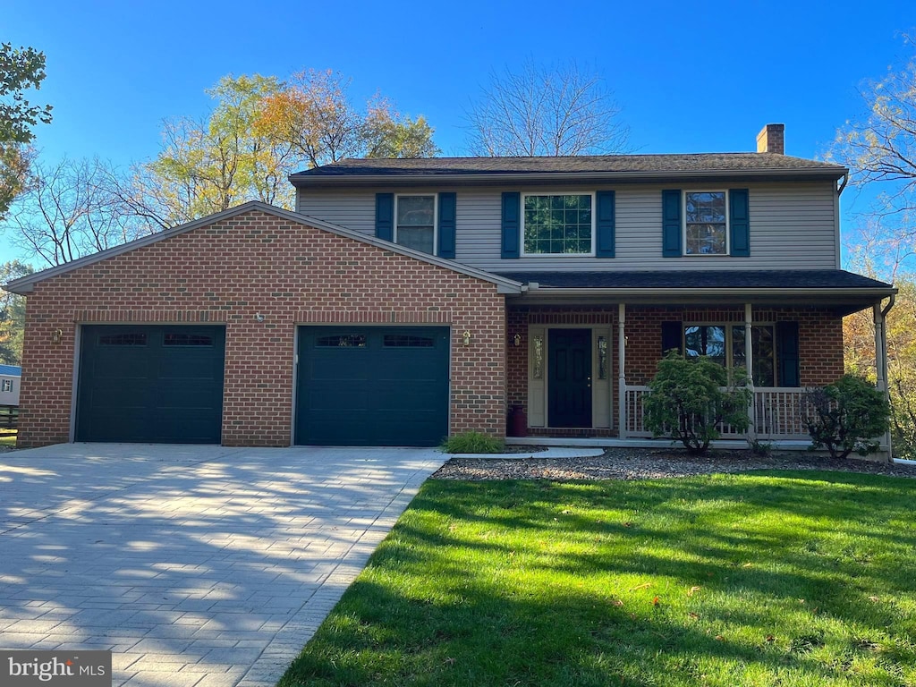 front of property featuring a porch, a front yard, and a garage