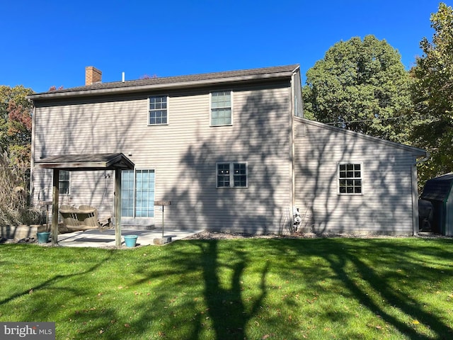 back of house featuring a patio area and a yard