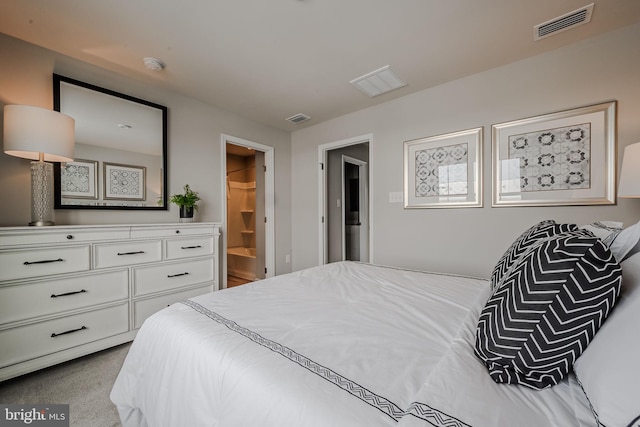 bedroom featuring ensuite bath and light carpet