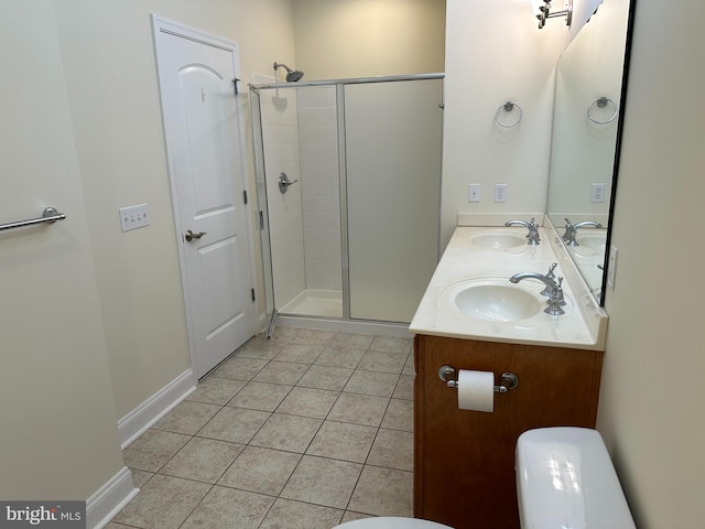 bathroom featuring tile patterned floors, vanity, a shower with shower door, and toilet