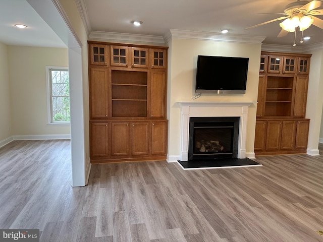 unfurnished living room with light hardwood / wood-style floors, ceiling fan, and ornamental molding