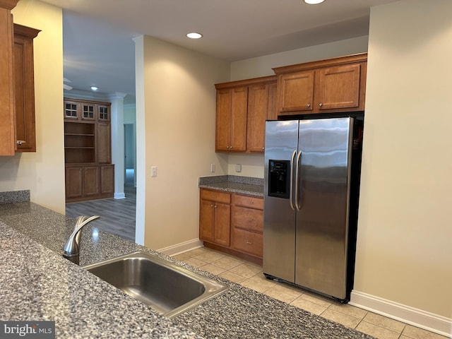 kitchen featuring stainless steel refrigerator with ice dispenser, light tile patterned floors, and sink