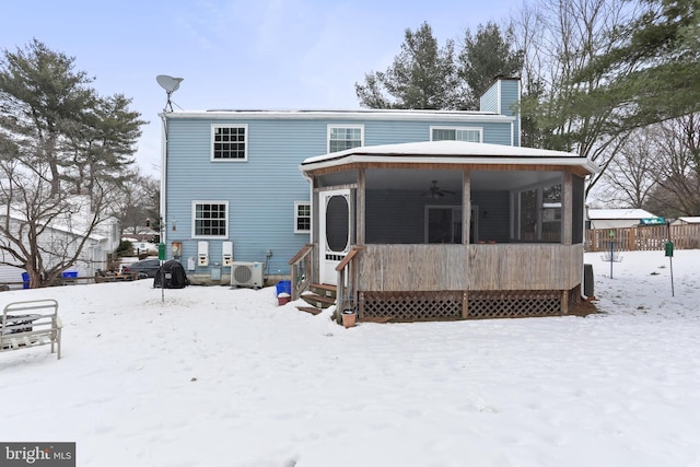 snow covered rear of property featuring ceiling fan and ac unit