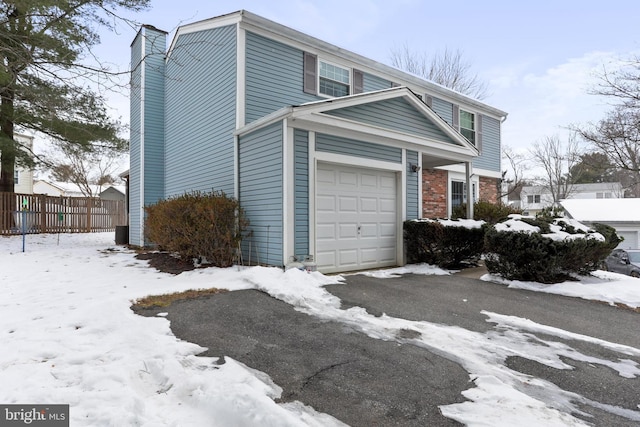 view of snowy exterior with a garage